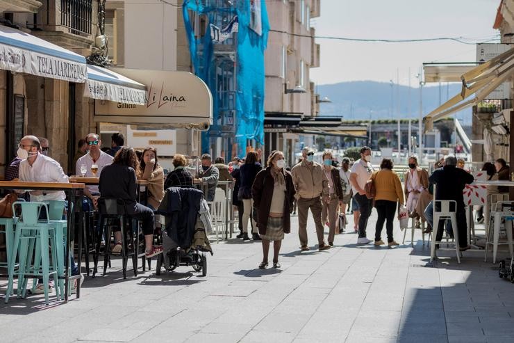 Varias persoas pasean por unha céntrica rúa de Sanxenxo 