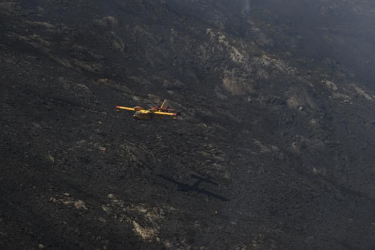 Un hidroavión traballa nos labores de extinción nun incendio na Serra do Leboreiro, nos montes do pobo de Senderiz, no parque natural de Baixa Limia e Serra do Xurés, 