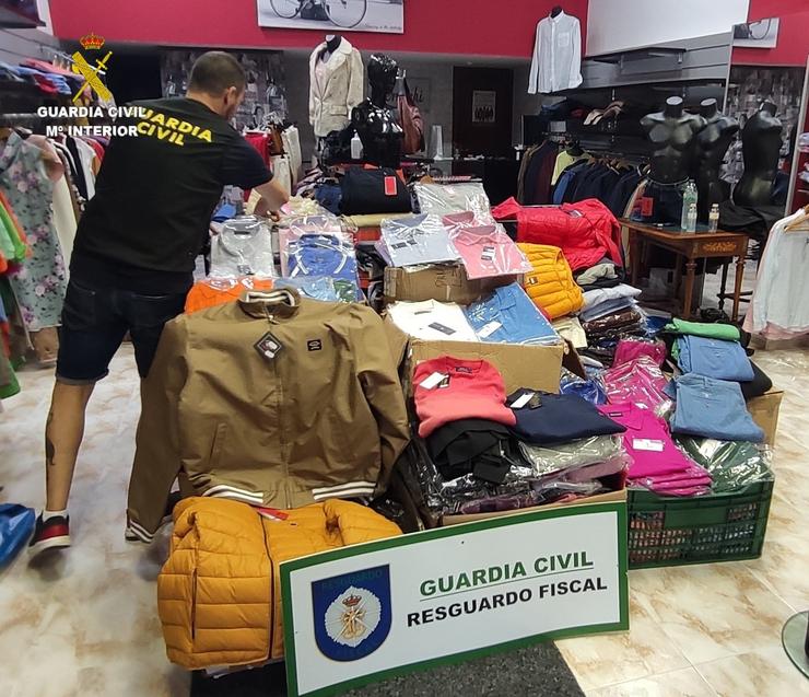 Pezas de roupa que a Garda Civil interviu no rexistro dun esteblecimento do Milladoiro por un suposto delito contra a propiedade industrial. GARDA CIVIL 