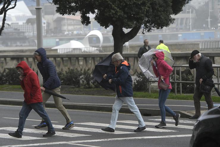 Varias persoas protéxense da choiva e o vento con paraugas, a 20 de outubro de 2023, na Coruña, Galicia (España).. M. Dylan - Europa Press / Europa Press