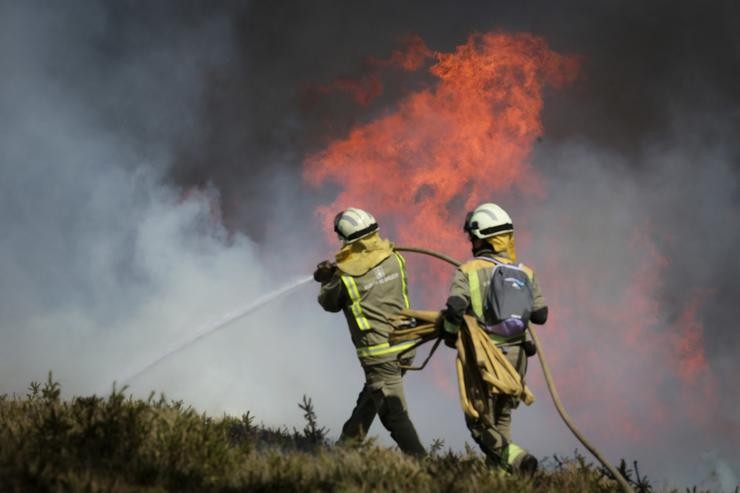 Efectivos da Xunta con base en Becerreá traballan para extinguir as chamas nun incendio forestal, a 29 de marzo de 2023, en Baleira, Lugo 