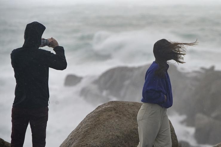 Unha persoa fotografa o mar embravecido, mentres o vento move a melena ao seu acompañante, a 4 de novembro de 2023, na Coruña, Galicia (España). A Axencia Estatal de Meteoroloxía (AEMET) activou na Coruña o aviso vermello pola chegada da. M. Dylan - Europa Press / Europa Press