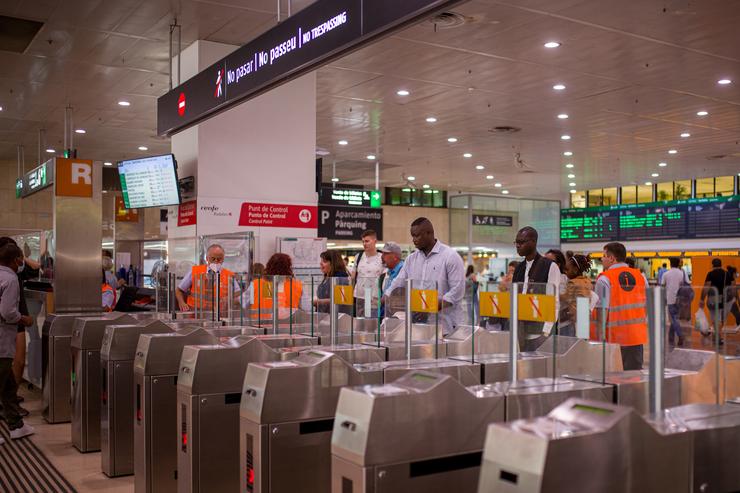 Viaxeiros cruzan os tornos da estación de Sants./ Lorena Sopêna