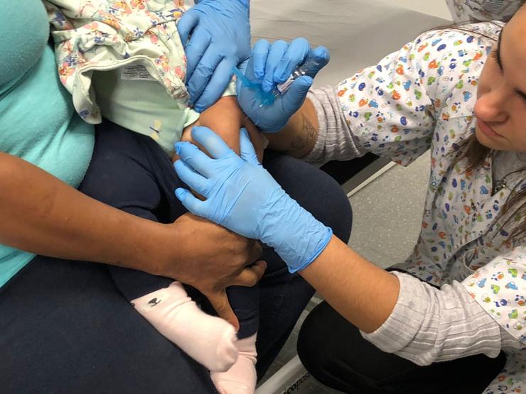 Unha enfermeira inocula a unha menor de 13 meses unha dose contra a gripe 
