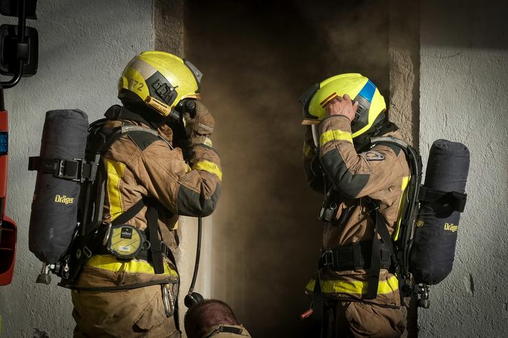 Dous bombeiros afrontan un lume / César Arxina - Arquivo