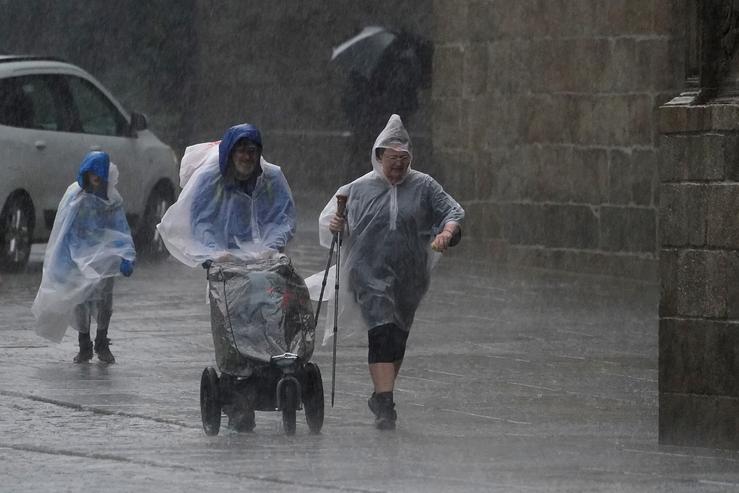 Varias persoas con chuvasqueiros durante o paso da borrasca ?Aline?, a 19 de outubro de 2023, en Santiago de Compostela, A Coruña, Galicia.. Álvaro Ballesteros - Europa Press - Arquivo 