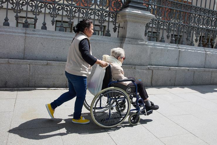 Unha muller maior en cadeira de rodas e a súa coidadora pasean polo centro da cidad / Jesús Hellín - Europa Press - Arquivo /