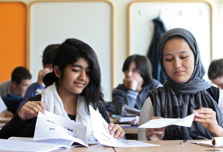 Dúas nenas migrantes estudando na clase 