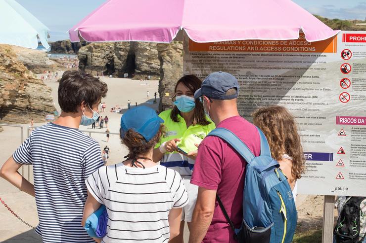 Turistas mostran os seus pases para acceder á praia das Catedrais./ Carlos Castro - Europa Press 