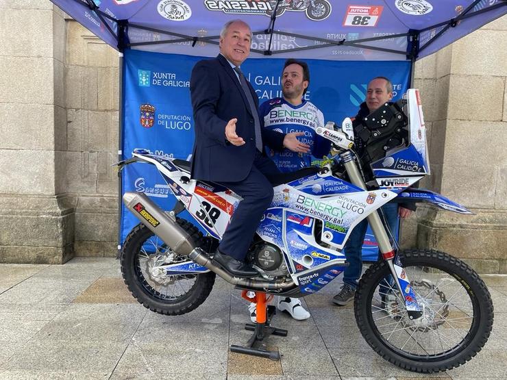 O presidente da Deputación de Lugo, José Tomé, subido á moto de Eduardo Iglesias, o piloto monfortino que recibirá unha axuda de 15.000 euros da institución provincial para disputar o Rally Dakar 2024. En Lugo, a 12 de decembro de 2023 / Europa Press