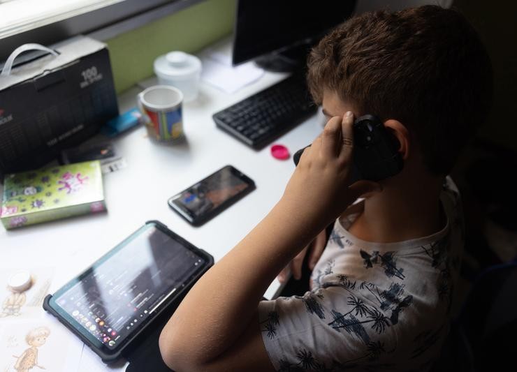 Un neno usa o teléfono móbil e unha tablet / Eduardo Parra - Europa Press