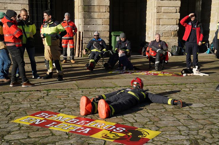 Un boneco vestido de bombeiro no chan durante unha concentración en forma de protesta pacífica, na Praza do Obradoiro, a 15 de decembro de 2023, en Santiago de Compostela 