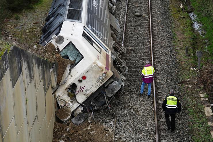 Dous homes realizan os labores de retirada do tren accidentado, a 24 de xaneiro de 2023, na Xesta, Lalín, Pontevedra (España).. Álvaro Ballesteros - Europa Press 