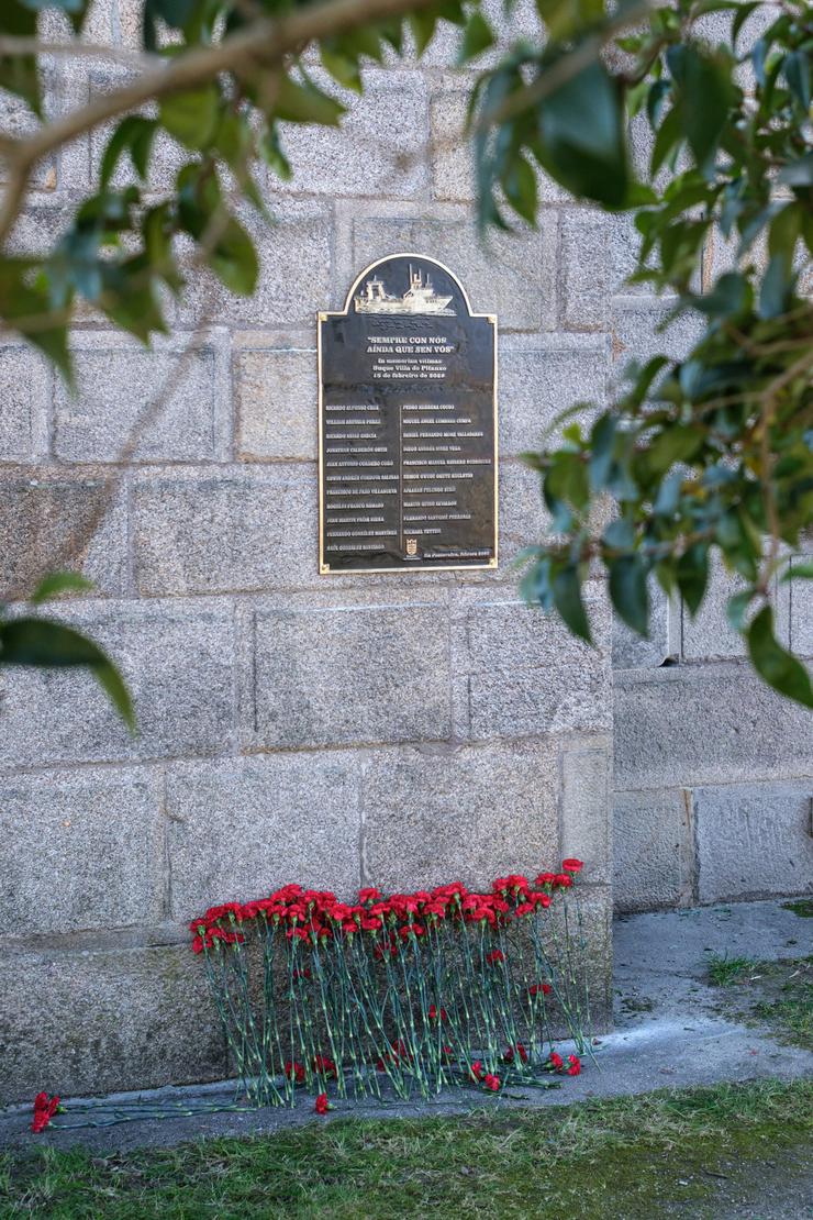 Caraveis vermellos baixo a placa cos nomes da tripulación desaparecida no naufraxio do Villa de Pitanxo instalada en Pontevedra / Europa Press 