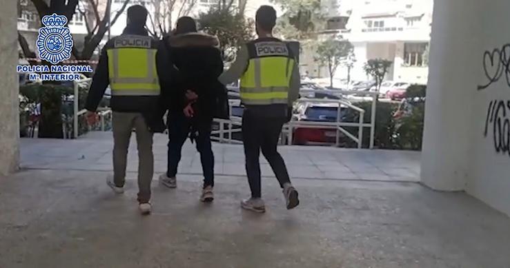 Axentes da Policía Nacional custodian a un dos arrestados / Europa Press