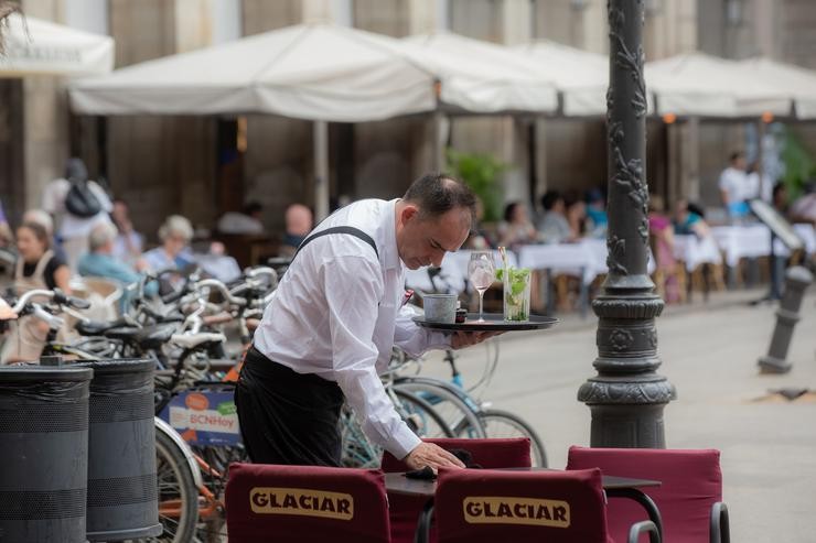 Un camareiro limpa unha mesa.  Europa Press