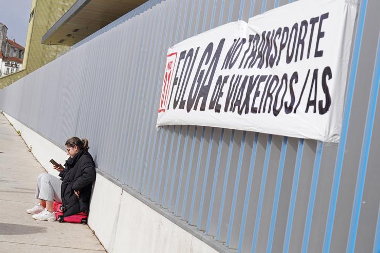 Unha muller á beira dun cartel da folga de transporte, tras unha concentración pola folga do transporte de viaxeiros, na estación de autobuses de Santiago, a 31 de marzo de 2023, en Santiago de Compostela, A Coruña, Galicia (España). A folga, c. Álvaro Ballesteros - Europa Press 