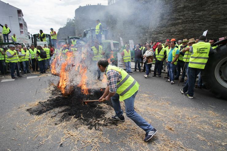 Un gandeiro fai unha fogueira con palla durante unha manifestación na Muralla de Lugo, a 11 de maio de 2023, en Lugo, Galicia (España). Convocada pola Asociación de Produtores de Tenreira Suprema Galega, os gandeiros volveron a protestar polos baixo. Carlos Castro - Europa Press / Europa Press