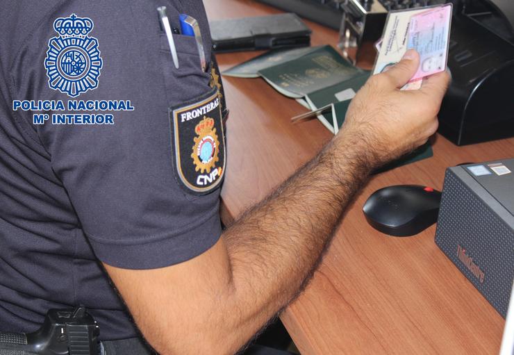 Un axente comproba un pasaporte nun posto fronteirizo / POLICÍA NACIONAL - Arquivo 