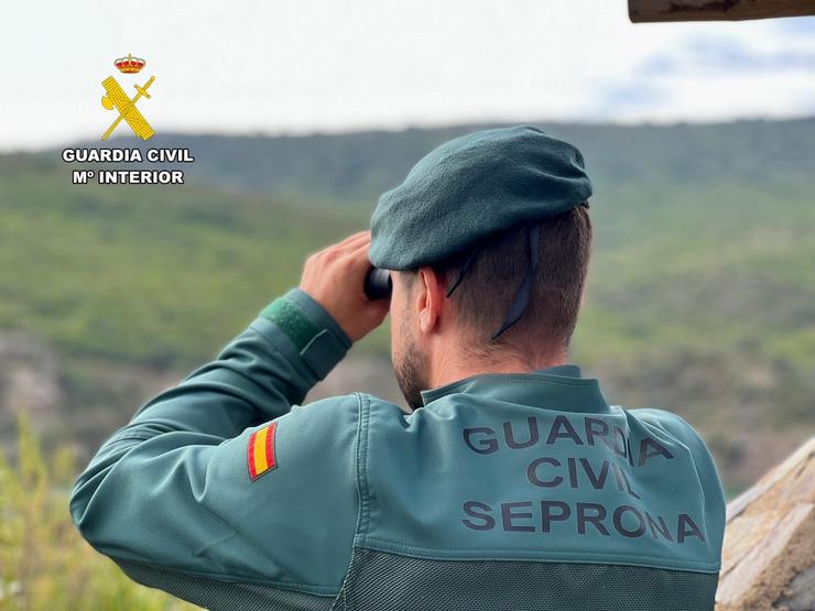 Un axente do Seprona da Garda Civil cuns prismáticos na busca dunha persoa desaparecida