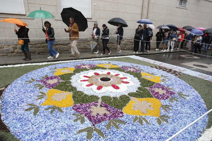 Varias persoas pasan á beira das alfombras florais en Ponteareas. Javier Vázquez - Europa Press - Arquivo 