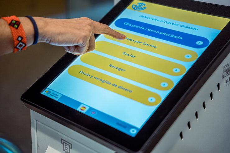 Unha persoa solicita o voto por correo no Edificio de correos 