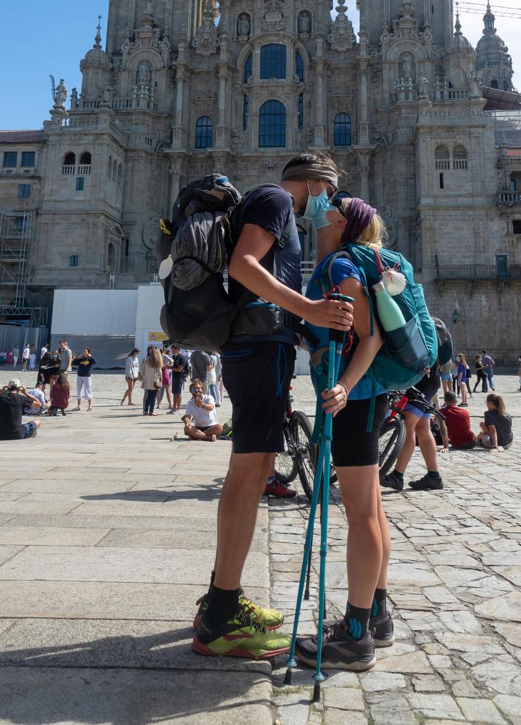 Unha parella de peregrinos italianos bícanse ao chegar á Praza do Obradoiro, despois de completar todos o percorrido do 'camiño francés' 