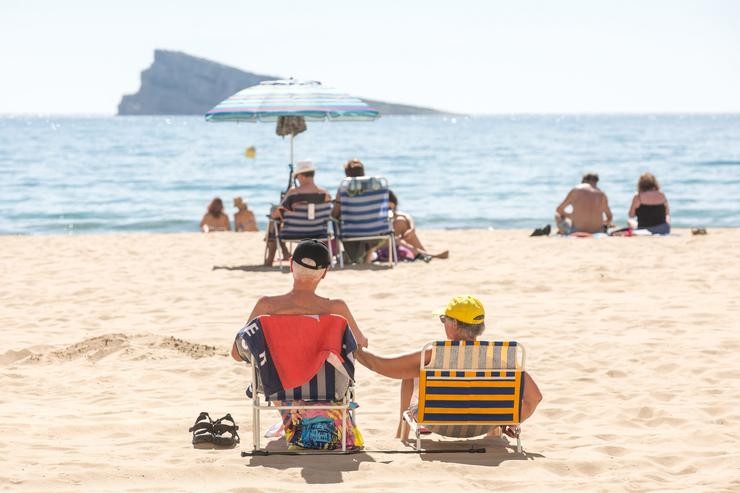 Numerosas persoas báñanse e toman o sol na praia de Poñente, a 11 de marzo de 2023, en Benidorm 