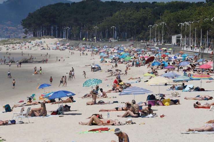 Varias persoas báñanse e toman o sol na praia de Samil, en Vigo / Marta Vázquez Rodríguez - Arquivo