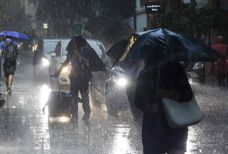 Varias persoas con paraugas baixo a choiva, /Rober Solsona - Europa Press 