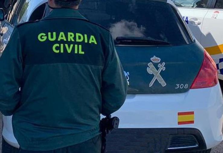 Un axente da Garda Civil de costas e xunto a un vehículo oficial do corpo / GARDA CIVIL - Arquivo