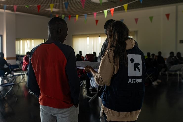 Varios migrantes procedentes de Canarias cunha voluntaria de Accem, na Casa de Cultura de Dorrón, a 17 de novembro de 2023, en Sanxenxo / Elena Fernández - Arquivo