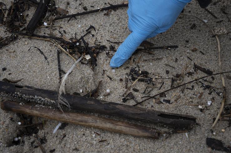 Un voluntario recolle pellets na praia de Samil, a 10 de xaneiro de 2024, en Vigo, Pontevedra. Adrián Irago - Europa Press 