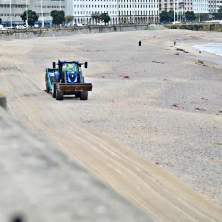 Tractores traballando na praia de Orzán, na Coruña 