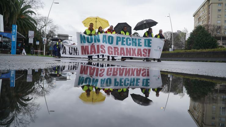 Manifestantes suxeitan pancartas durante unha protesta en defensa do sector primario, nunha protesta convocada por Agromuralla 