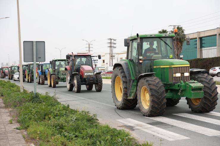 Tractores en tractorada cortando unha estrada 