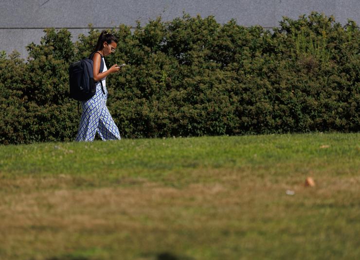 Unha estudante paseando por un camiño da universidade 