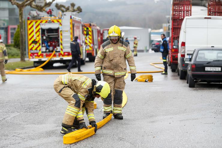 Bombeiros nas inmediacións dunha nave de despezamento onde se produciu un incendio, no polígono de Ou Ceao, a 26 de marzo de 2024, en Ou Ceao, Lugo, Galicia (España). Os servizos de emerxencia tratan de sufocar un incendio na nave da empresa. Carlos Castro - Europa Press