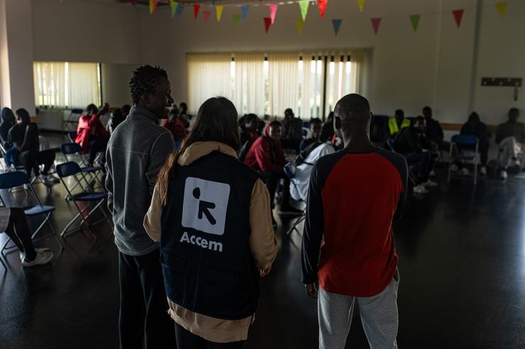 Varios migrantes procedentes de Canarias cunha voluntaria de Accem, na Casa de Cultura de Dorrón, a 17 de novembro de 2023, en Sanxenxo / Elena Fernández - Arquivo
