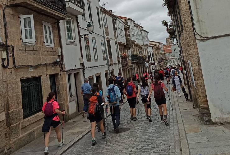 Peregrinos baixan polo medio da Rúa de San Pedro, en Santiago de Compostela / Europa Press