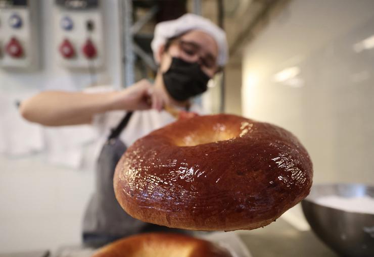 Unha empregada decora un roscón de Reis nunha pastalaría / Eduardo Parra