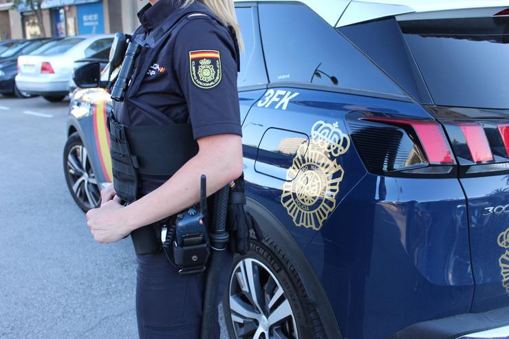 Imaxe dunha axente e dun coche patrulla da Policía Nacional / POLICÍA NACIONAL
