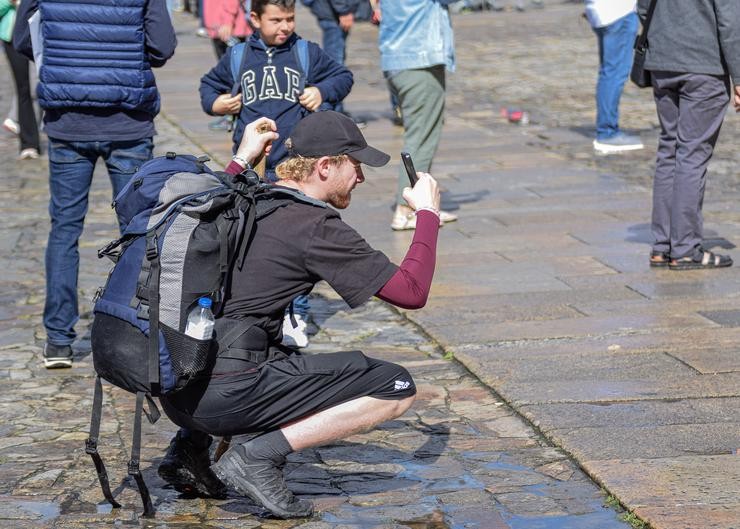 Un turista toma unha fotografía na praza do Obradoiro / David Gómez Pérez