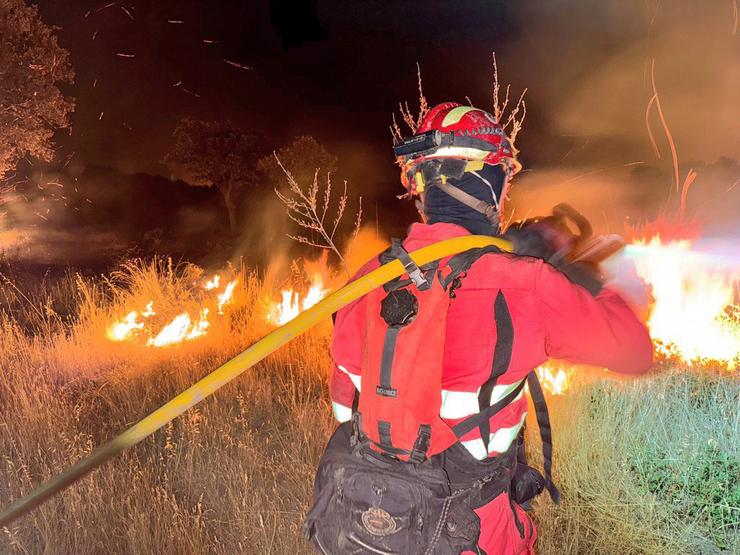 Unha axente da Unidade Militar de Emerxencias (UME) traballa nos labores de extinción dun incendio 