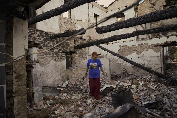 Unha muller observa a súa casa destruída polo incendio 