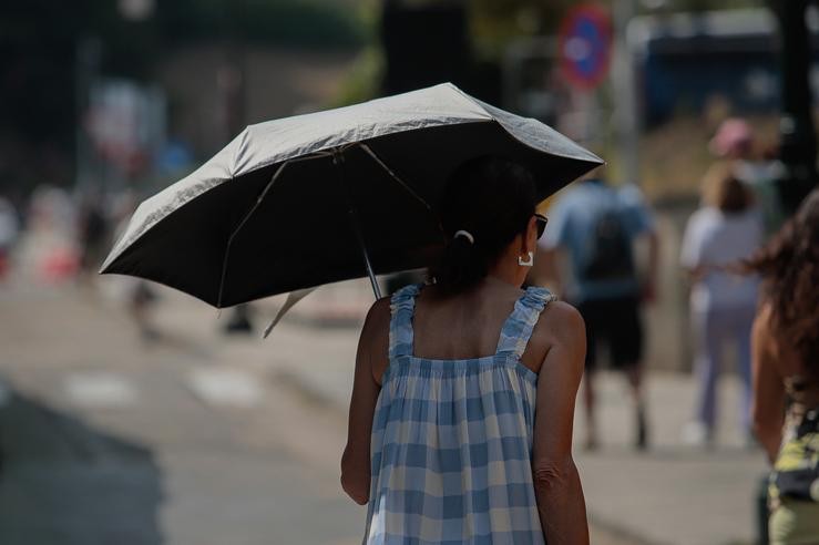 Unha muller protéxese do sol cunha antuca, a 5 de agosto de 2025, en Vigo, Pontevedra, Galicia (España). A Axencia Estatal de Meteoroloxía (Aemet) activou avisos laranxas e amarelos en máis de 30 provincias por temperaturas extremas durante o i. Adrián Irago - Europa Press 