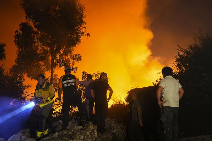 Varias persoas tratan de extinguir o lume, a 5 de agosto de 2025, en Ponteceso 