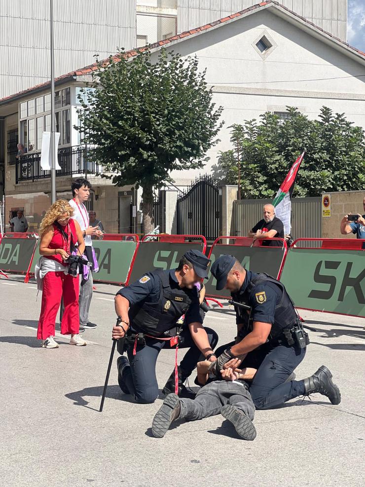 Dous axentes da Policía Nacional deteñen a un home durante as  protestas propalestinas en La Vuelta en Monforte